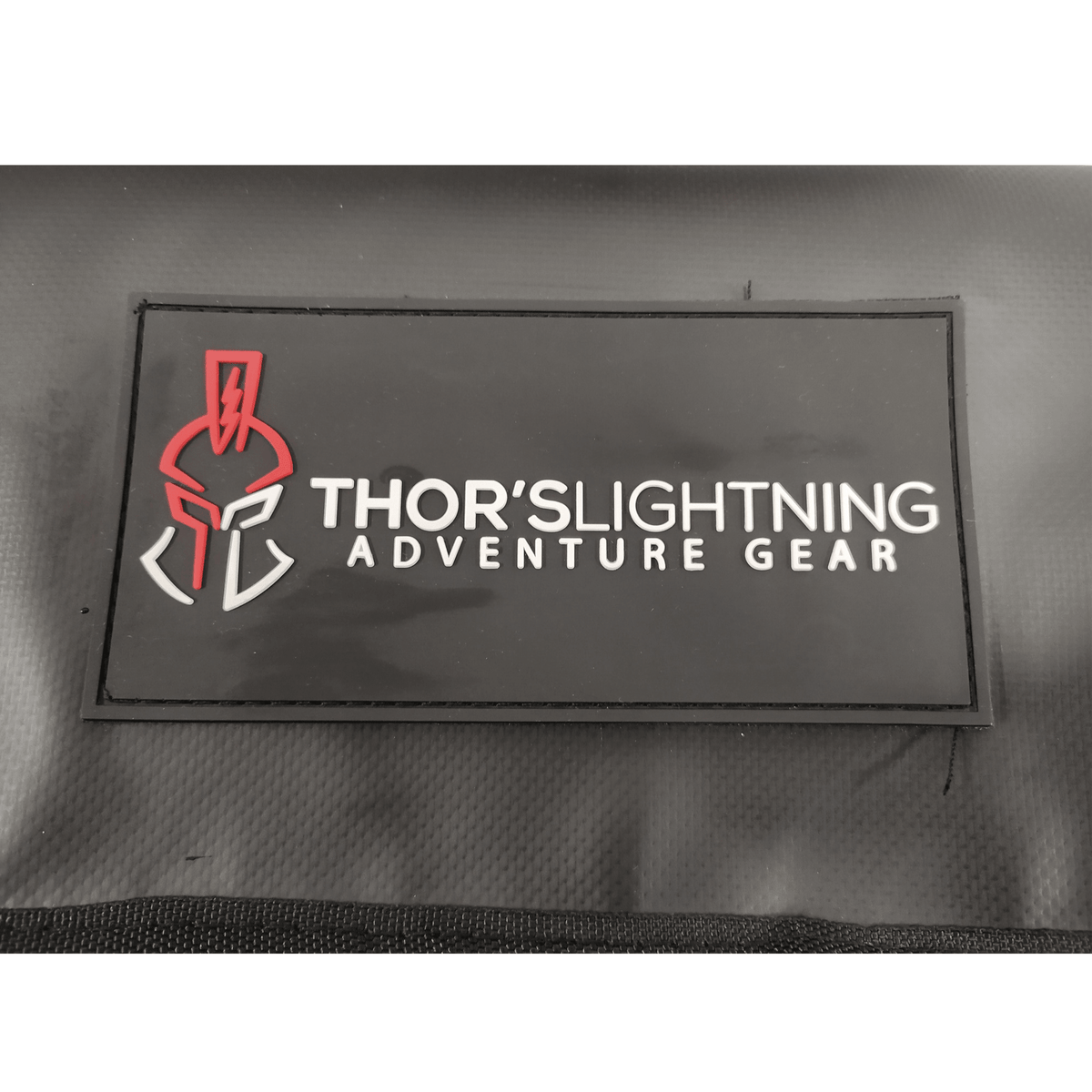 Close-up of the Thor's Lightning Adventure Gear logo patch on the compressor's carrying bag