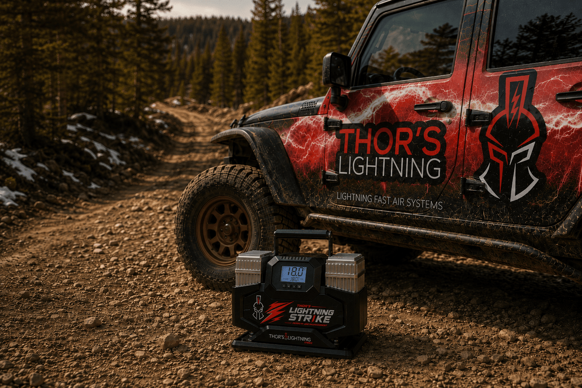 Lifestyle photo of Lightning Strike Pro compressor on a dirt trail beside a Thor's Lightning branded Jeep Wrangler