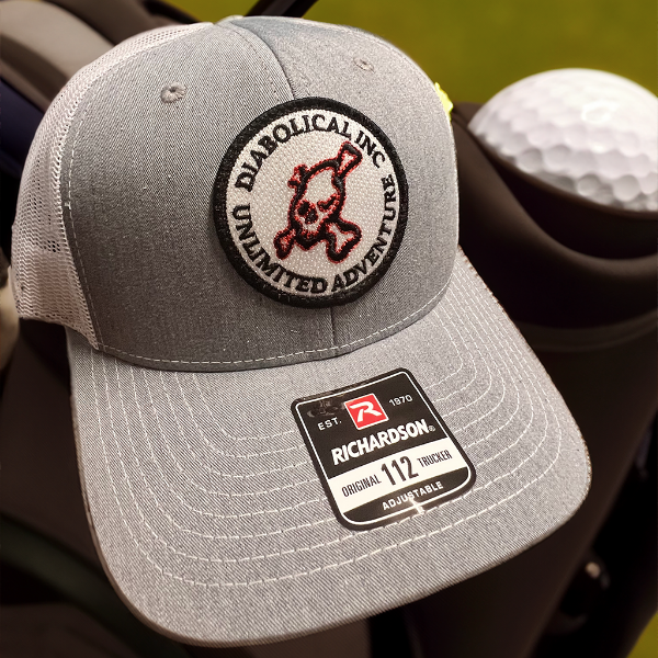 Gray trucker hat close-up showing the skull Unlimited Adventure patch