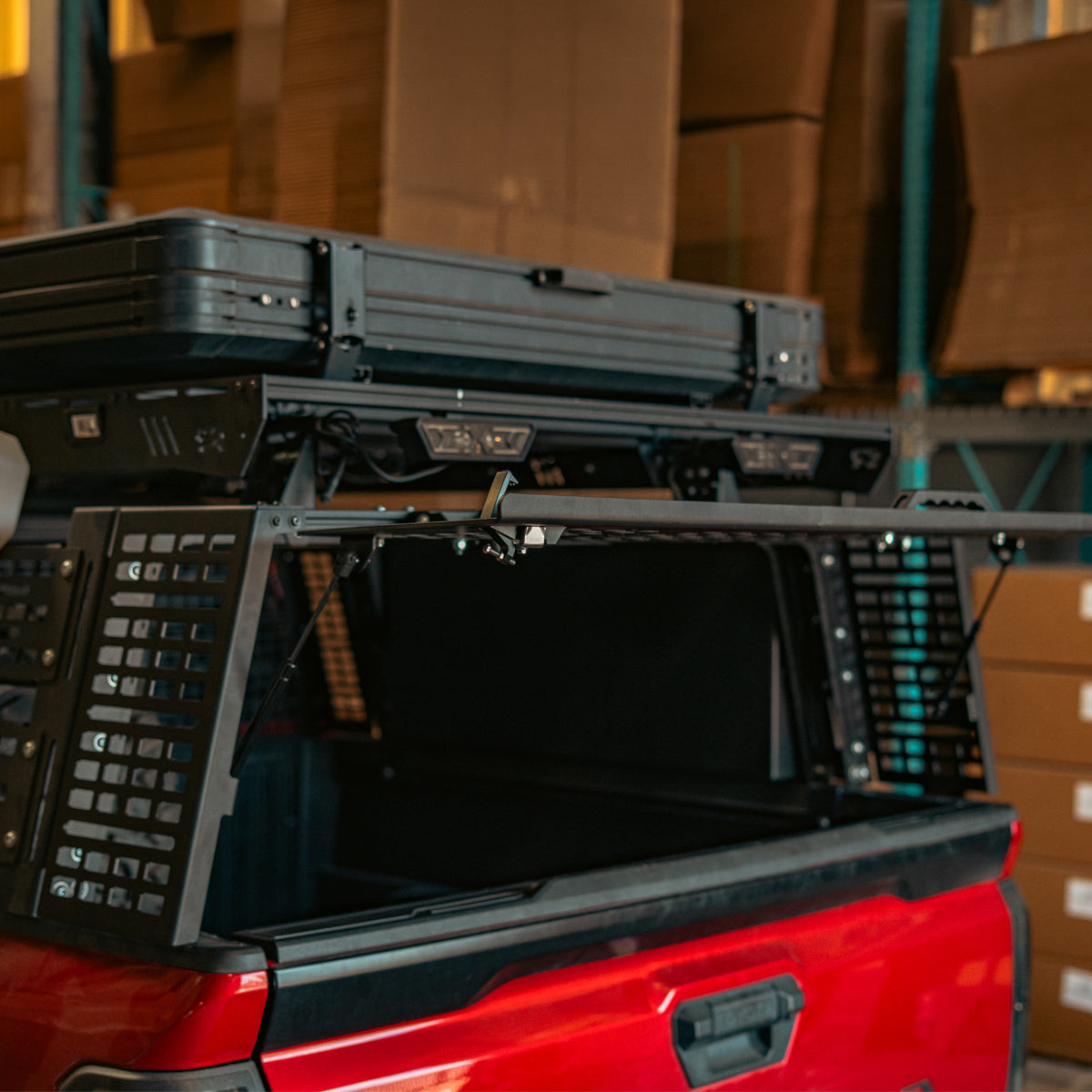 Open bed rack at the back of a red truck with the rear hatch removed