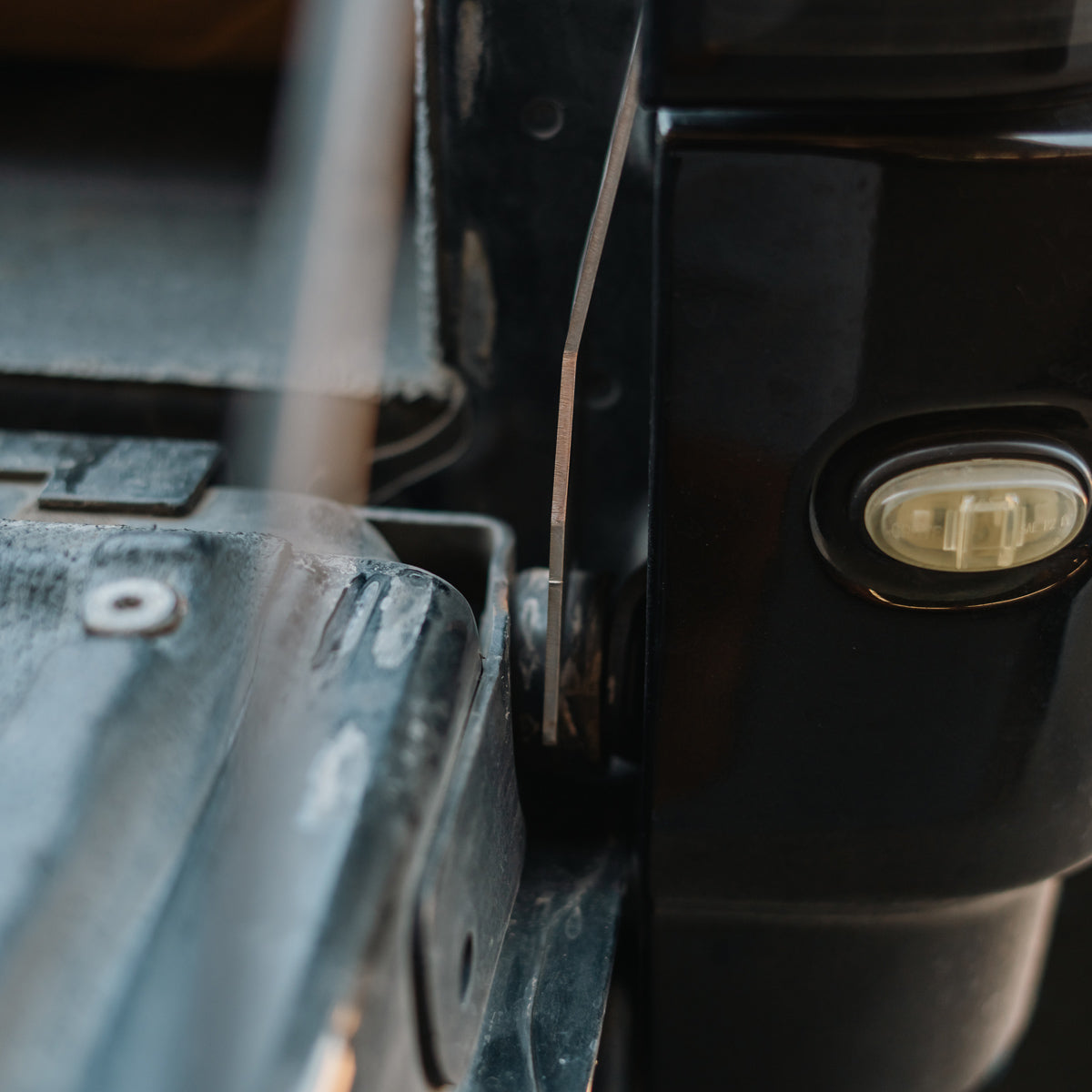 Cali Raised LED tailgate theft protector installed on a dark gray Ford F-150 tailgate, wider view showing the taillight