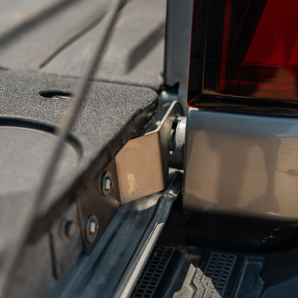 Cali Raised LED tailgate theft protector installed on a Chevy Silverado tailgate, wider view showing the taillight