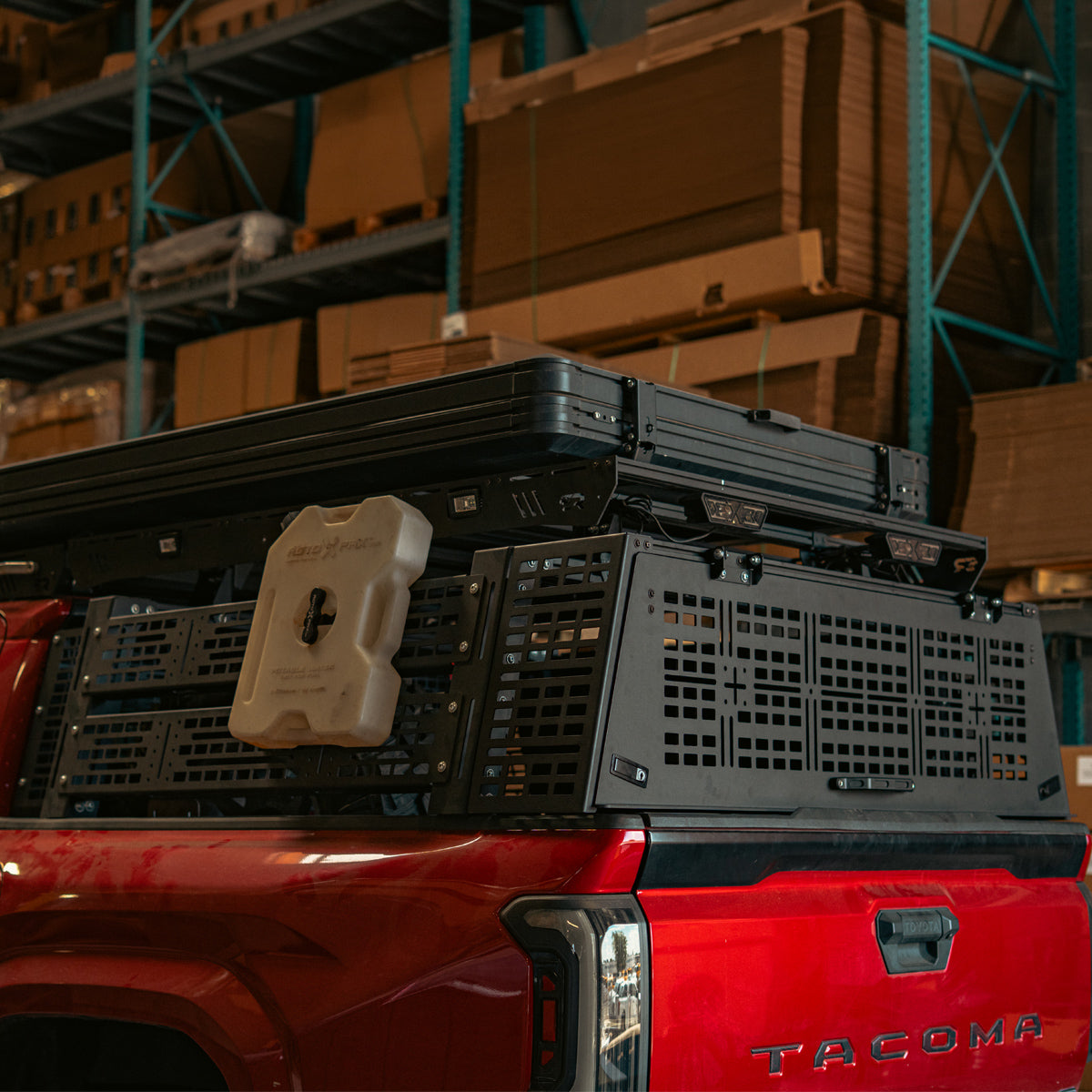 Rear hatch propped open above the truck bed with a spare tire in the bed