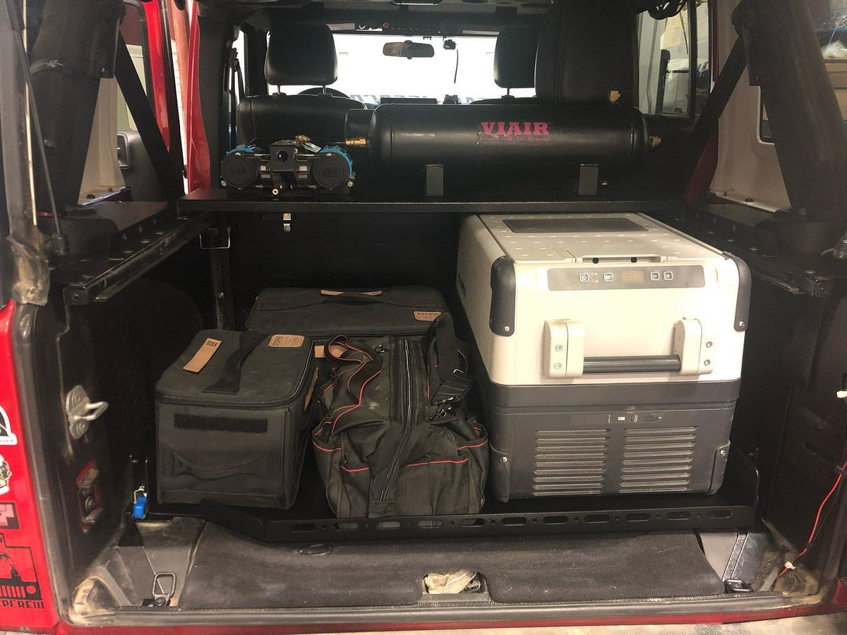 JKU slide floor retracted with a Dometic fridge and bags loaded