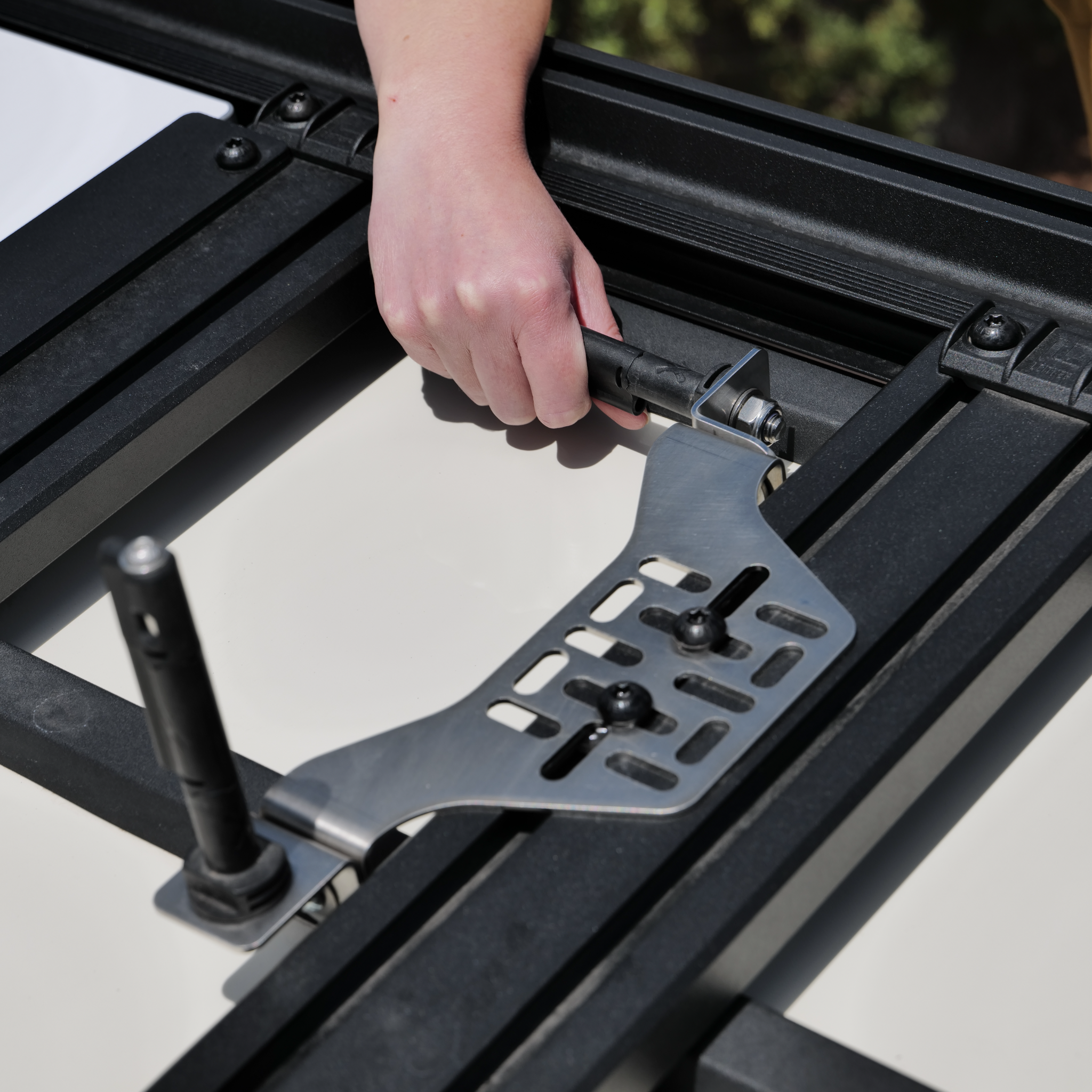 Stealth Folding Mount with Maxtrax Pins attached, Showing hand folding one pin down