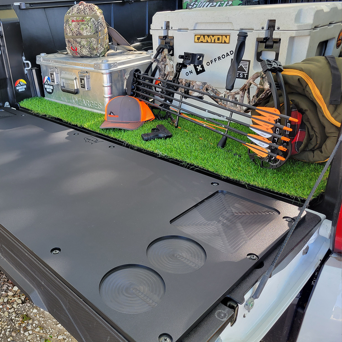Mountain Hatch recessed-pocket tailgate table on a 2022+ Toyota Tundra tailgate with hunting gear and a cooler in the bed