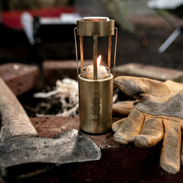 Brass UCO Candlelier candle lantern collapsed to its compact packed-down size, held in one hand