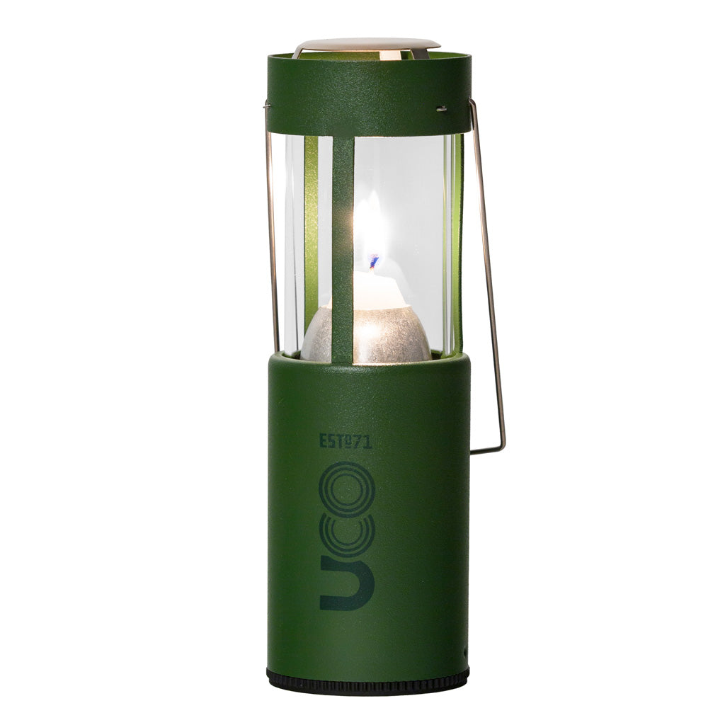 Forest green UCO Candlelier candle lantern standing upright and lit