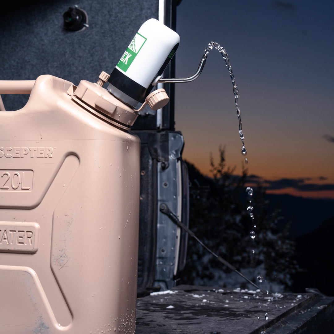 Lone Rock Concepts pump dispensing an arc of water from a tan 20L Scepter can in a truck bed at sunset