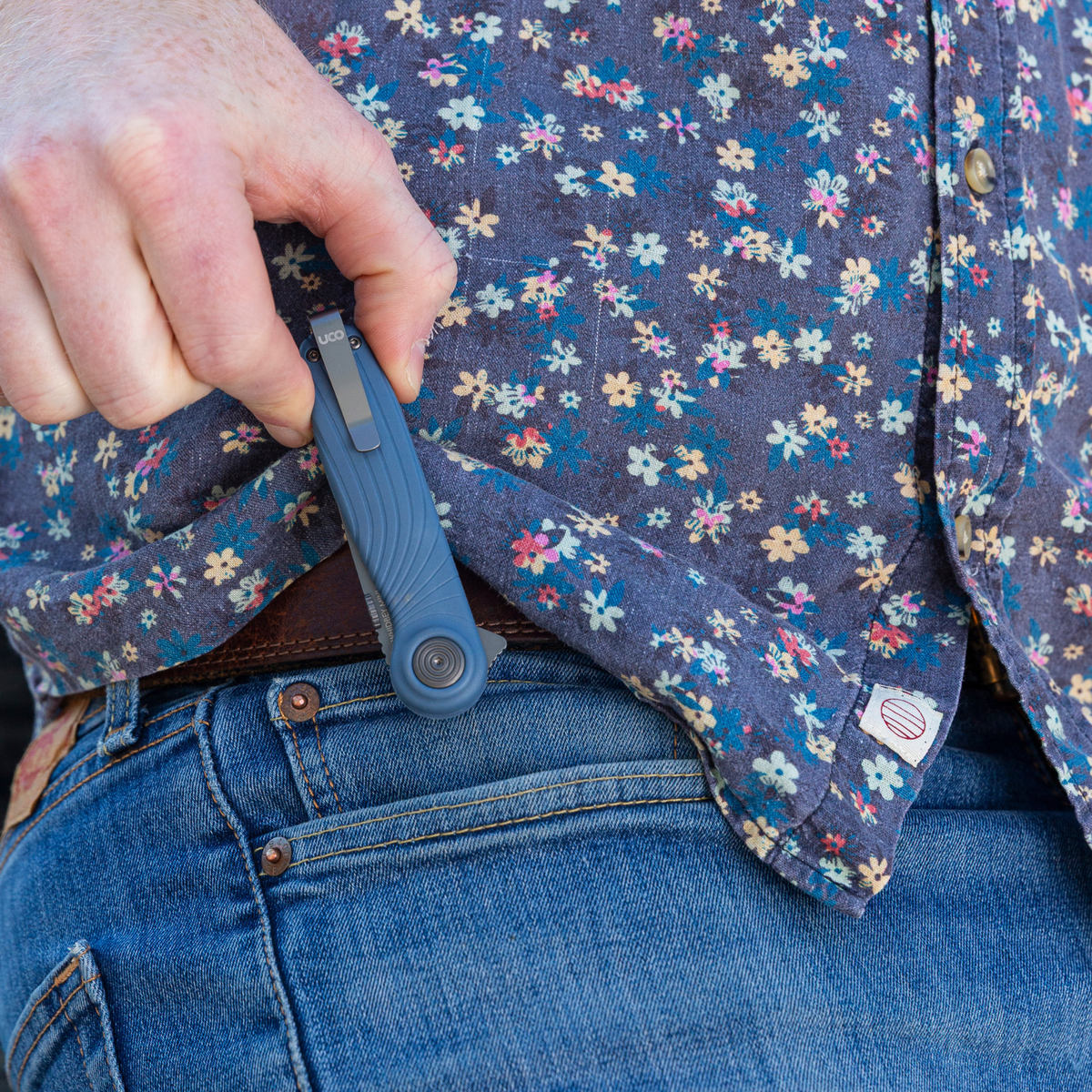 Man in a fleece jacket with a folding knife clipped to his jeans pocket