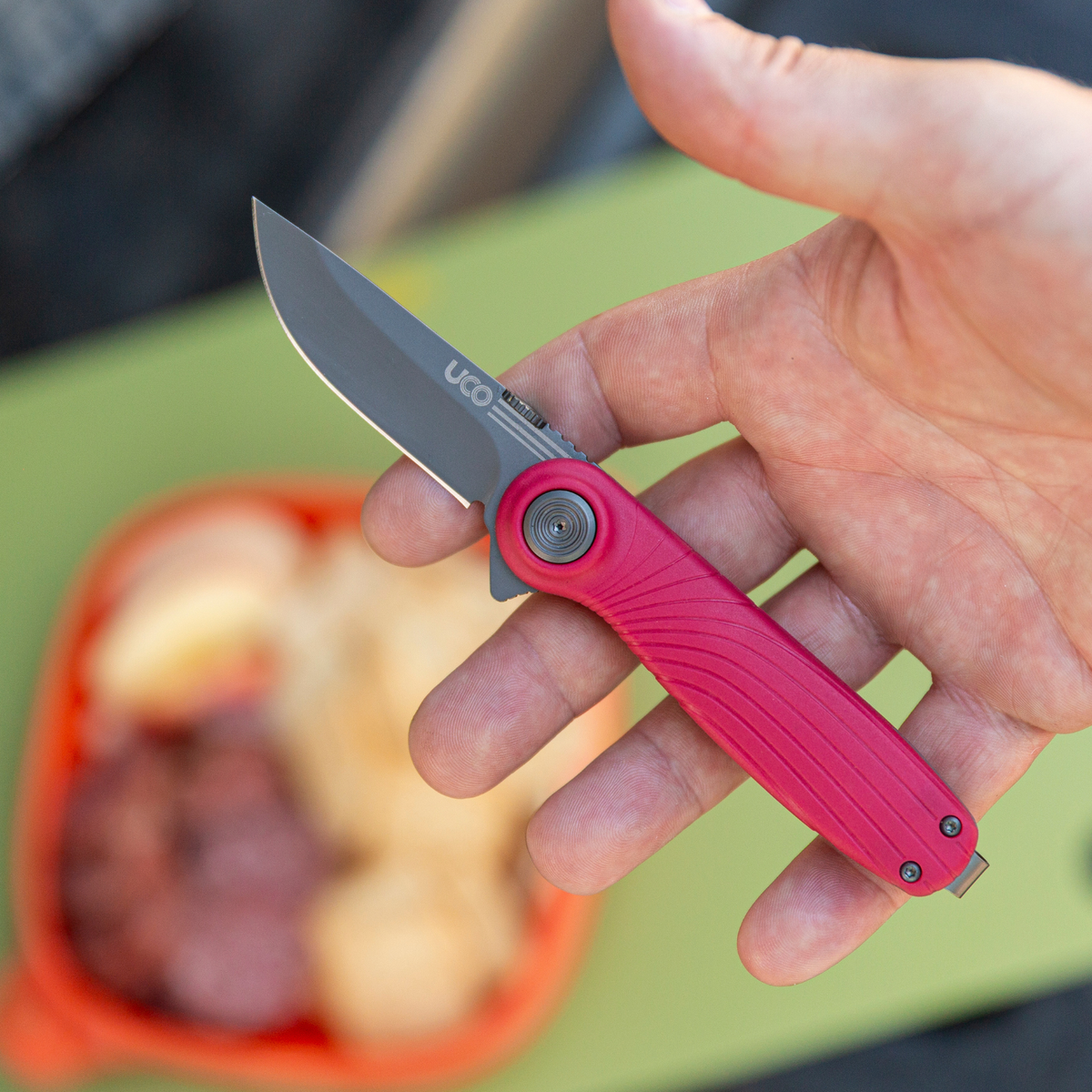 Magenta UCO Whidbey Mini folding knife open and held in hand