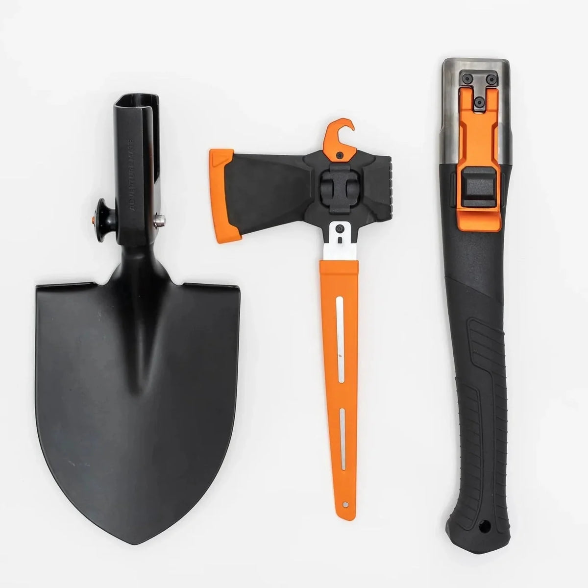 Adventure Mate multitool components laid flat on white: shovel head, axe head with orange blade guard, and the handle