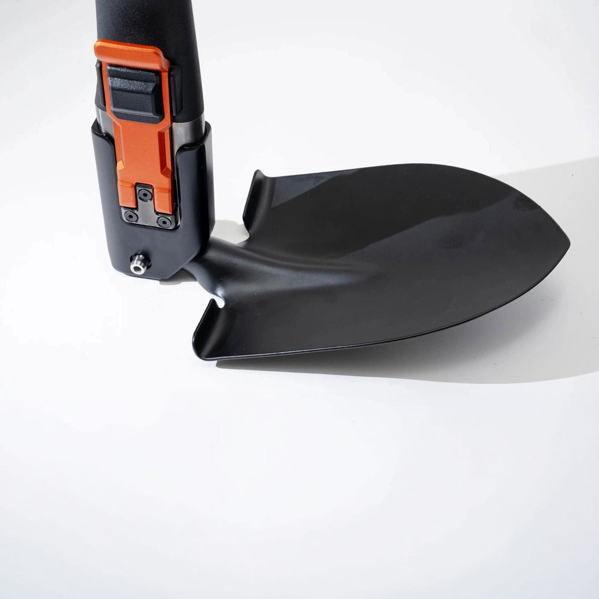 Close-up of the Adventure Mate shovel head attached to the handle with the orange locking lever