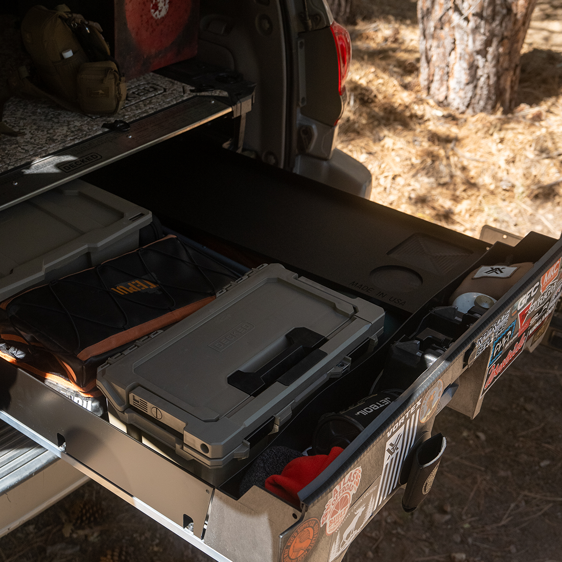 Grab n' Go cutting board on a drawer system beside a cooler and storage boxes in a truck bed