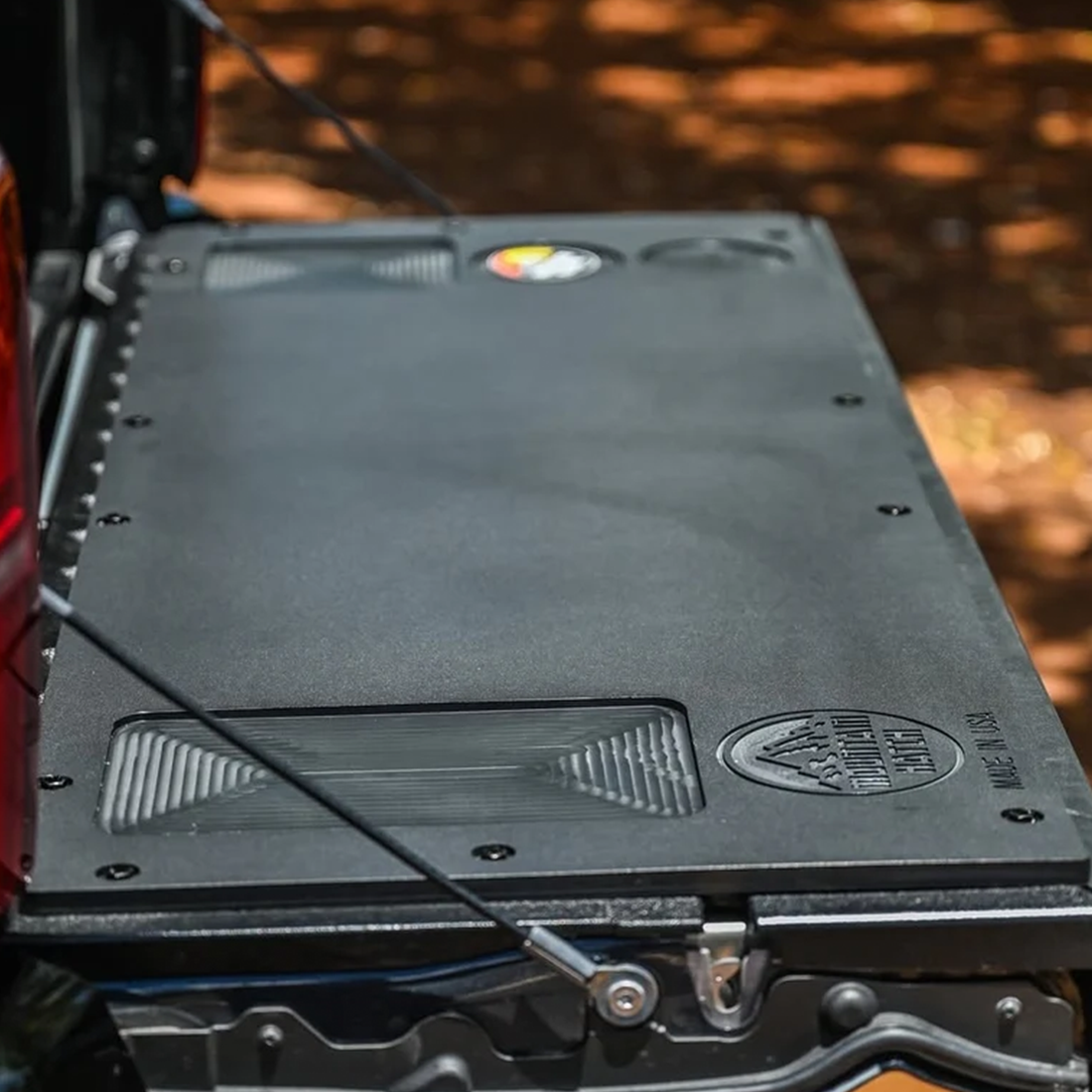 Mountain Hatch recessed-pocket tailgate table shown installed on a Toyota Tacoma tailgate (representative photo for the 2016-2024 Nissan Titan panel), with drink holders and utility tray