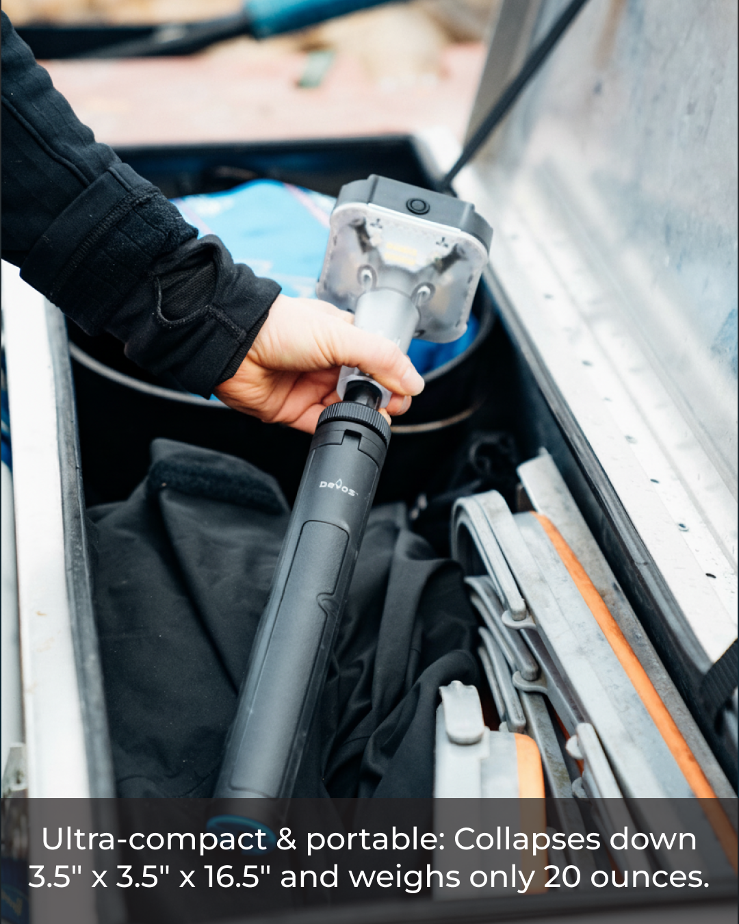 Person holding a compact and portable Devos Mini in a vehicle's storage compartment.