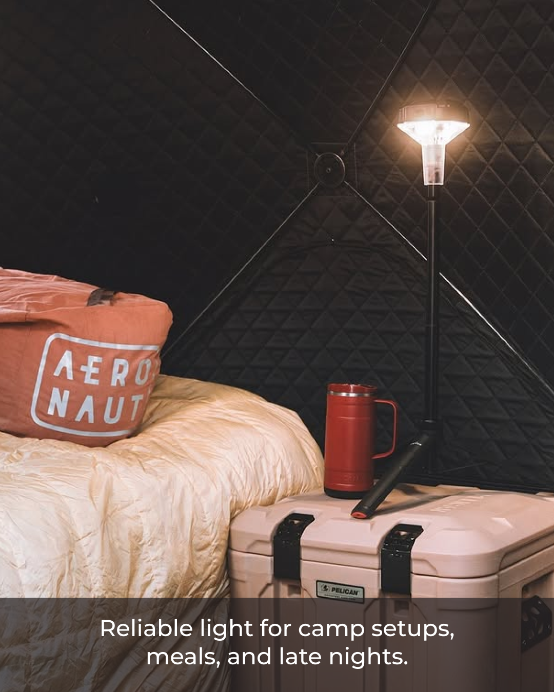 Outdoor setting with a tent, sleeping bag, and camping gear under a portable devos mini.