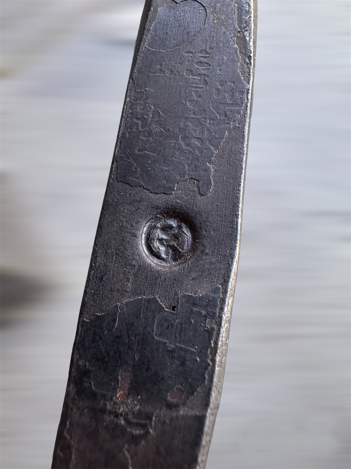 Extreme close-up of a leather glove's stitched seam and embossed flame emblem