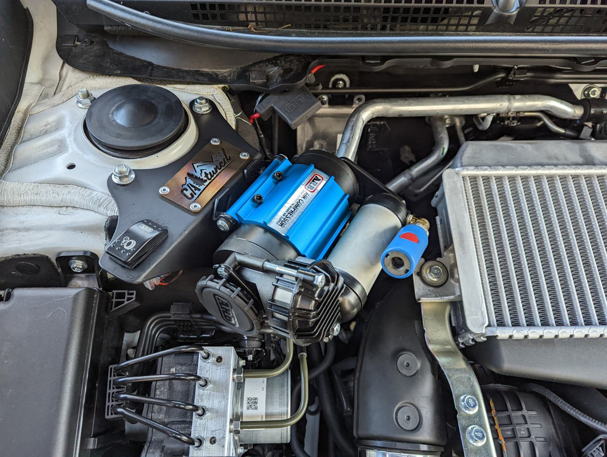 Blue compressor installed in an engine bay next to an intercooler