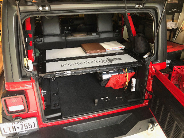 Light gray logo pad on a Slipstream in a red Jeep JLU, tailgate open