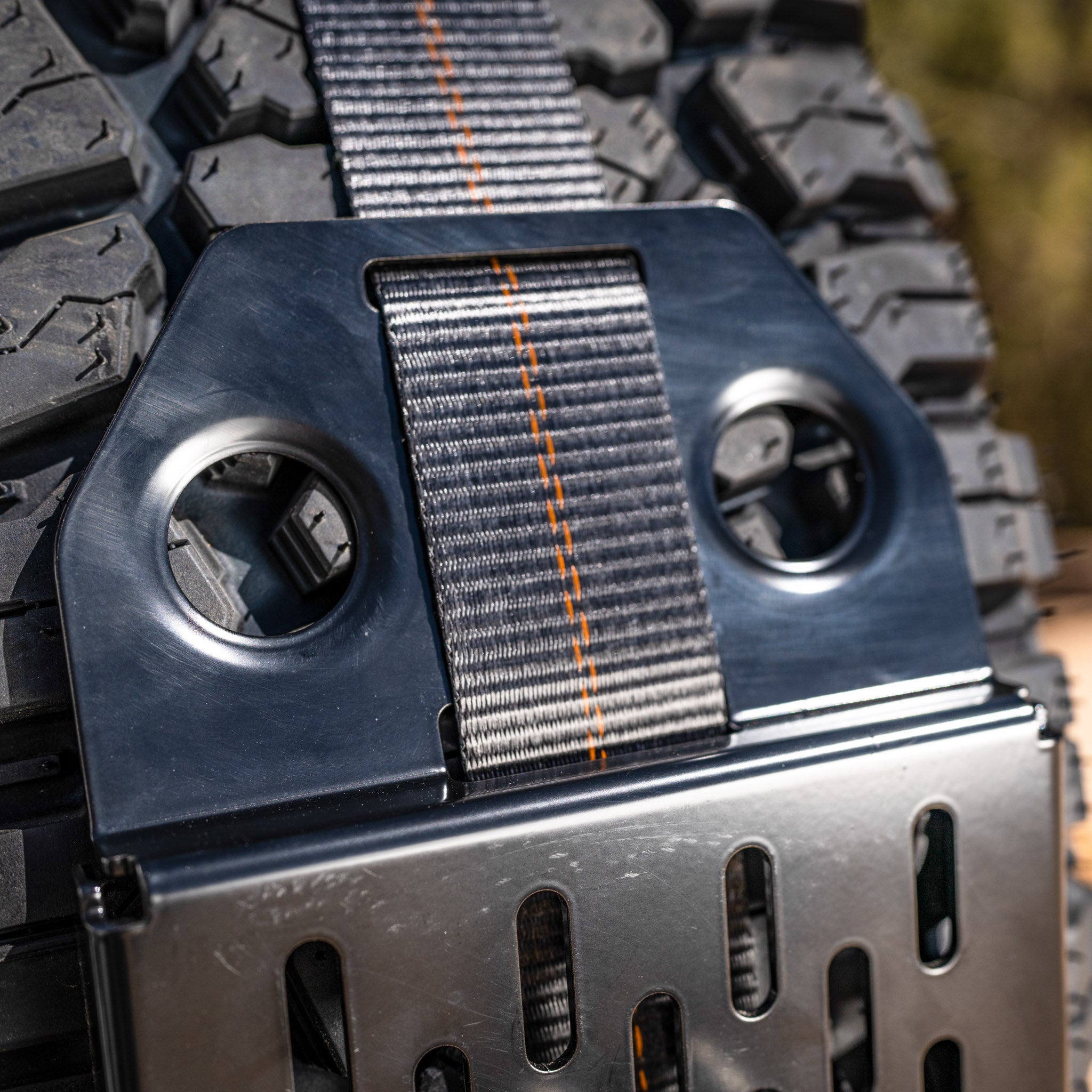 Detail shot of the spare tire bracket dimple dies and strap webbing of the spare tire mount for maxtrax 