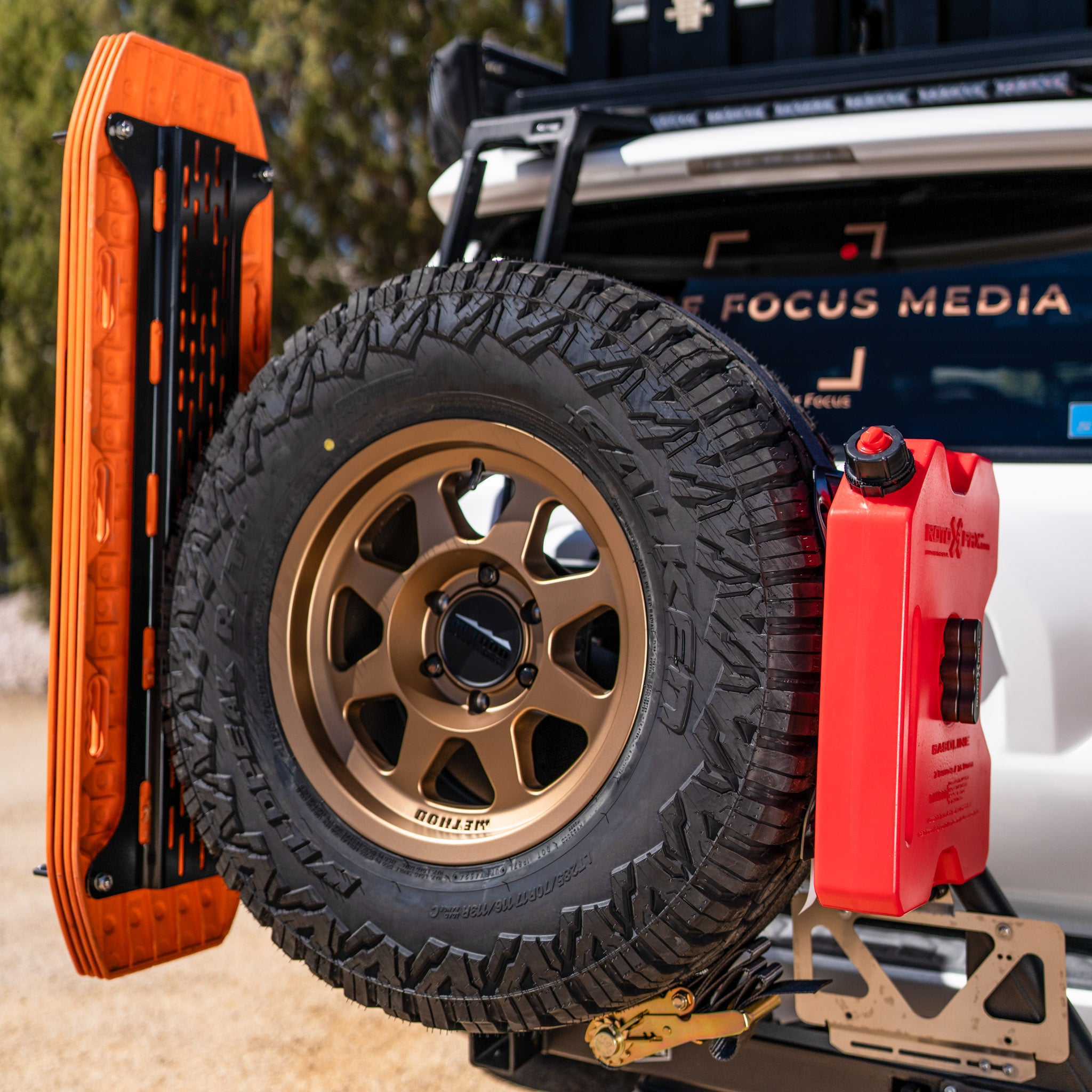 The Overland Kitted Spare Tire Mount featuring 4 orange maxtrax mounted and one red rotopax mounted.