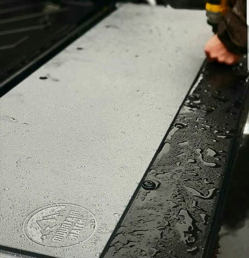 Wet Mountain Hatch tailgate table showing the textured HDPE surface and stamped logo