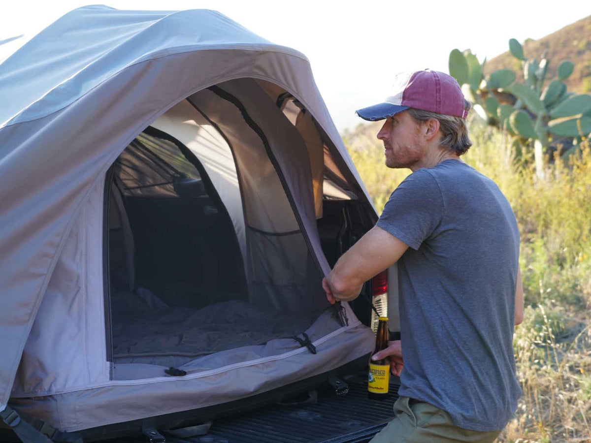 C6 Rev Pickup Truck Tent – person at the tent opening on a pickup truck