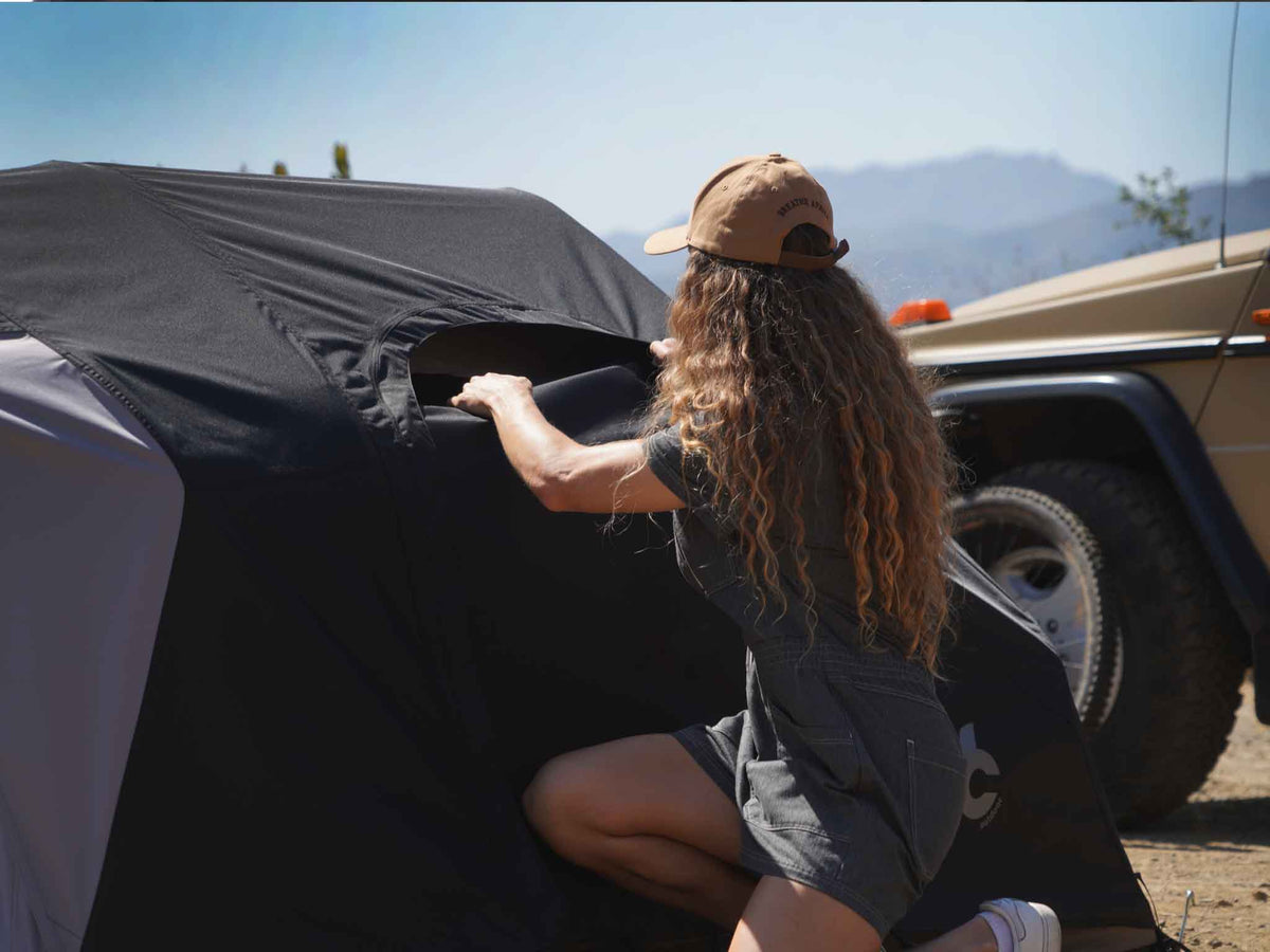 C6 Rev Tent (Eclipse) – hand securing a tent pole at the base