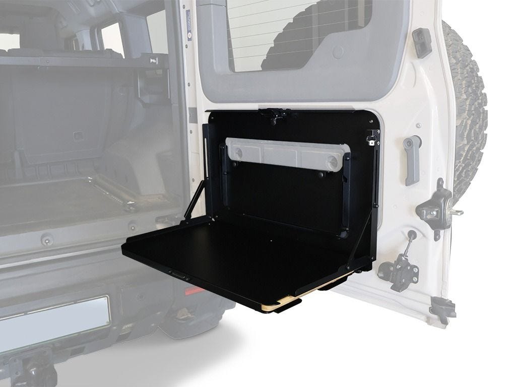 Front Runner drop down tailgate table folded open on the Ineos Grenadier rear swing door with the small secondary tray stowed above the main tray