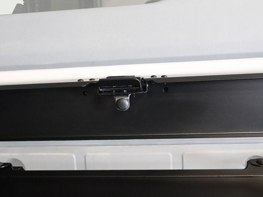 Close-up of the latch at the top of the Front Runner tailgate table holding it closed against the Ineos Grenadier door
