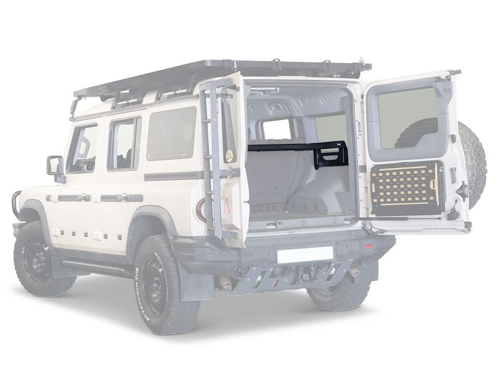 Rear three-quarter view of a white Ineos Grenadier with rear doors open and a Front Runner Cargo Molle Interior Shelf installed across the load bay