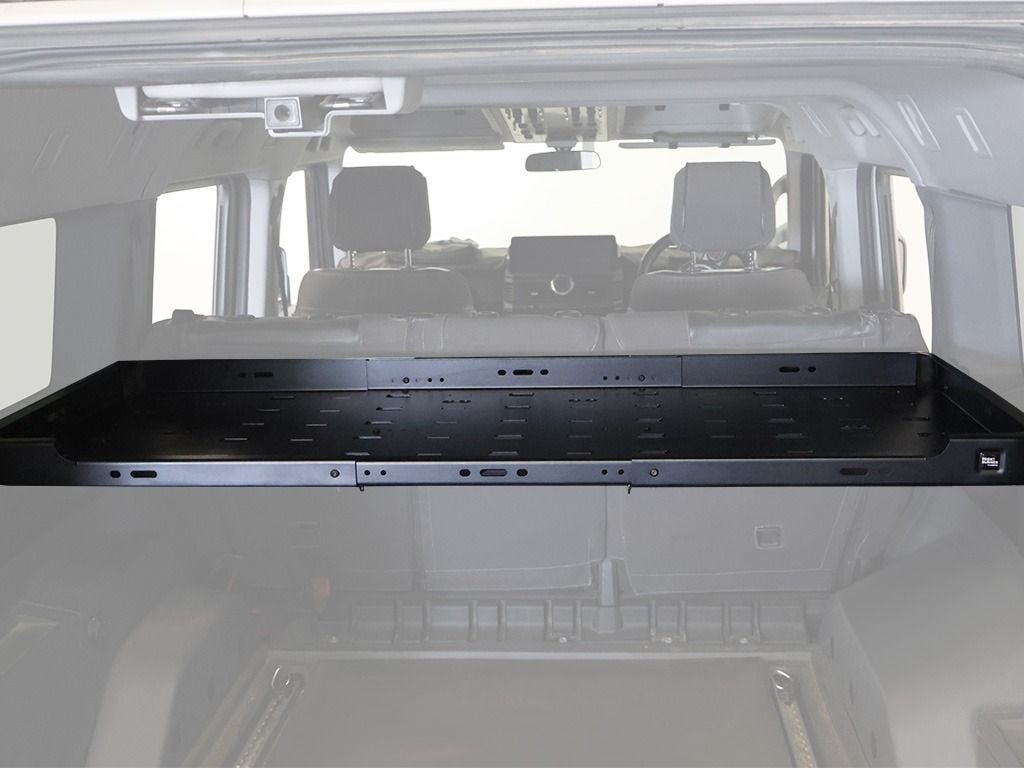 Black steel Front Runner Cargo Molle Interior Shelf mounted across the Ineos Grenadier cargo area, seen from inside looking forward