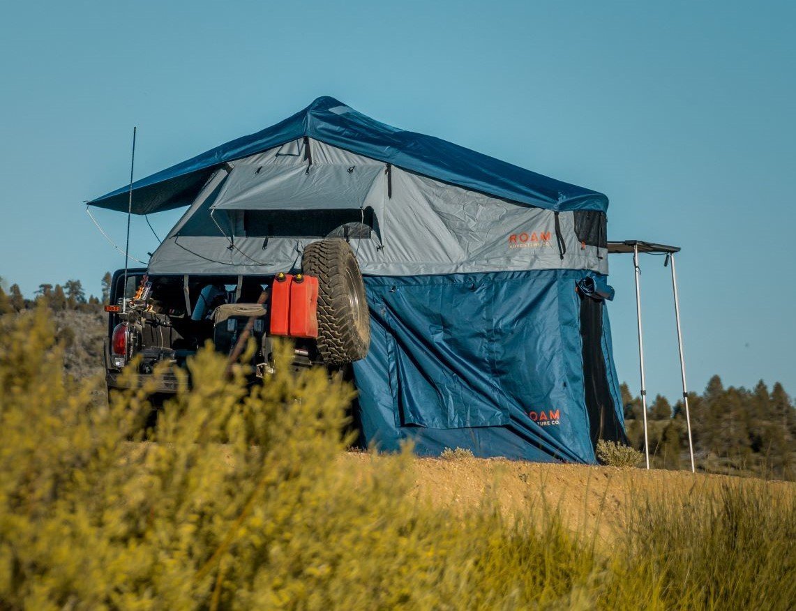 Slate grey ROAM Vagabond tent annex room providing weather cover at camp
