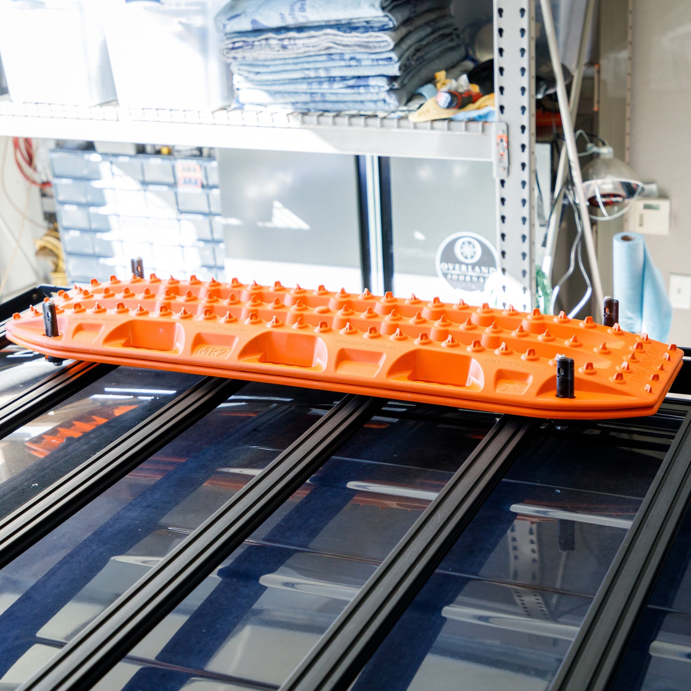Overland Kitted Flat Roof Rack Mount For MAXTRAX -Mounted on a Front Runner Roof rack, with orange MAXTRAX